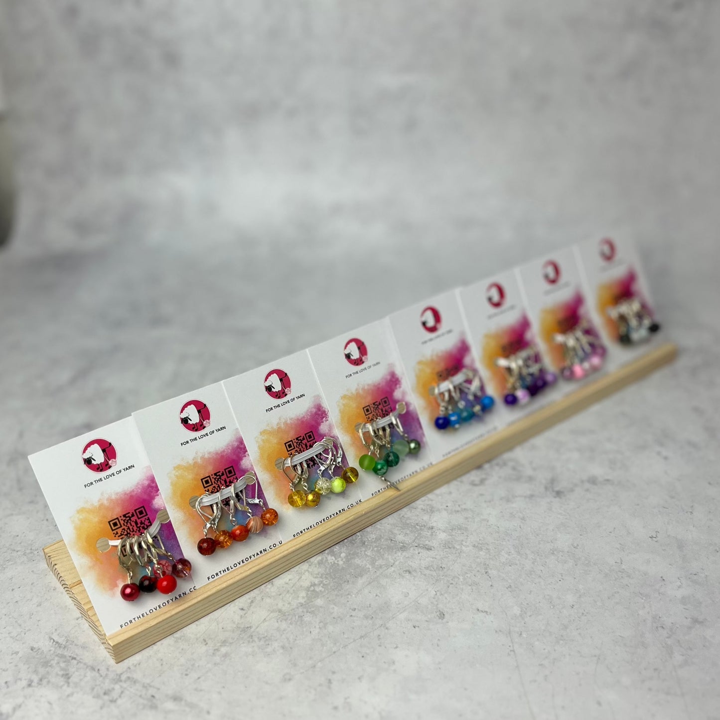 Row of crochet stitch markers, sets organised in rainbow order.