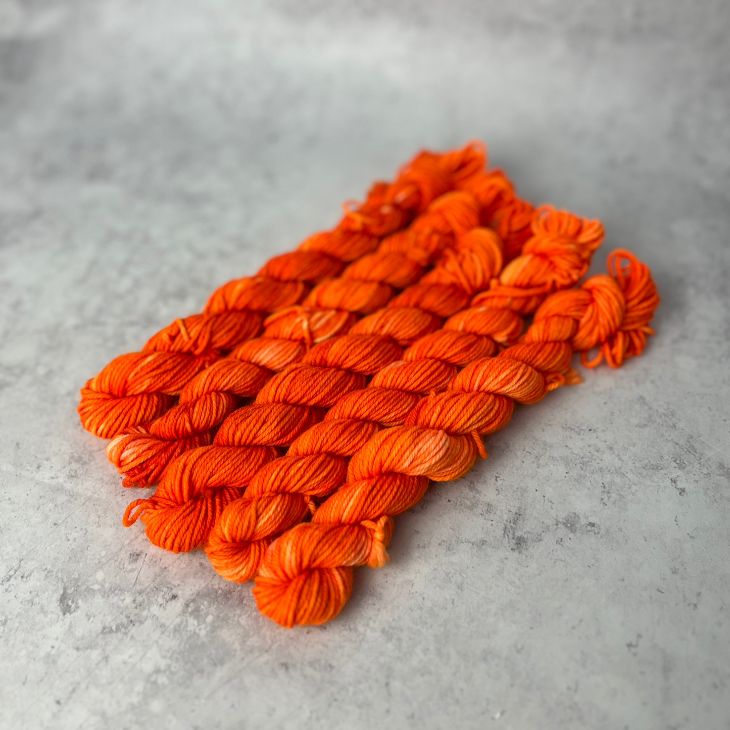 Orange Merino Neon Mini skein shown against a neutral background.