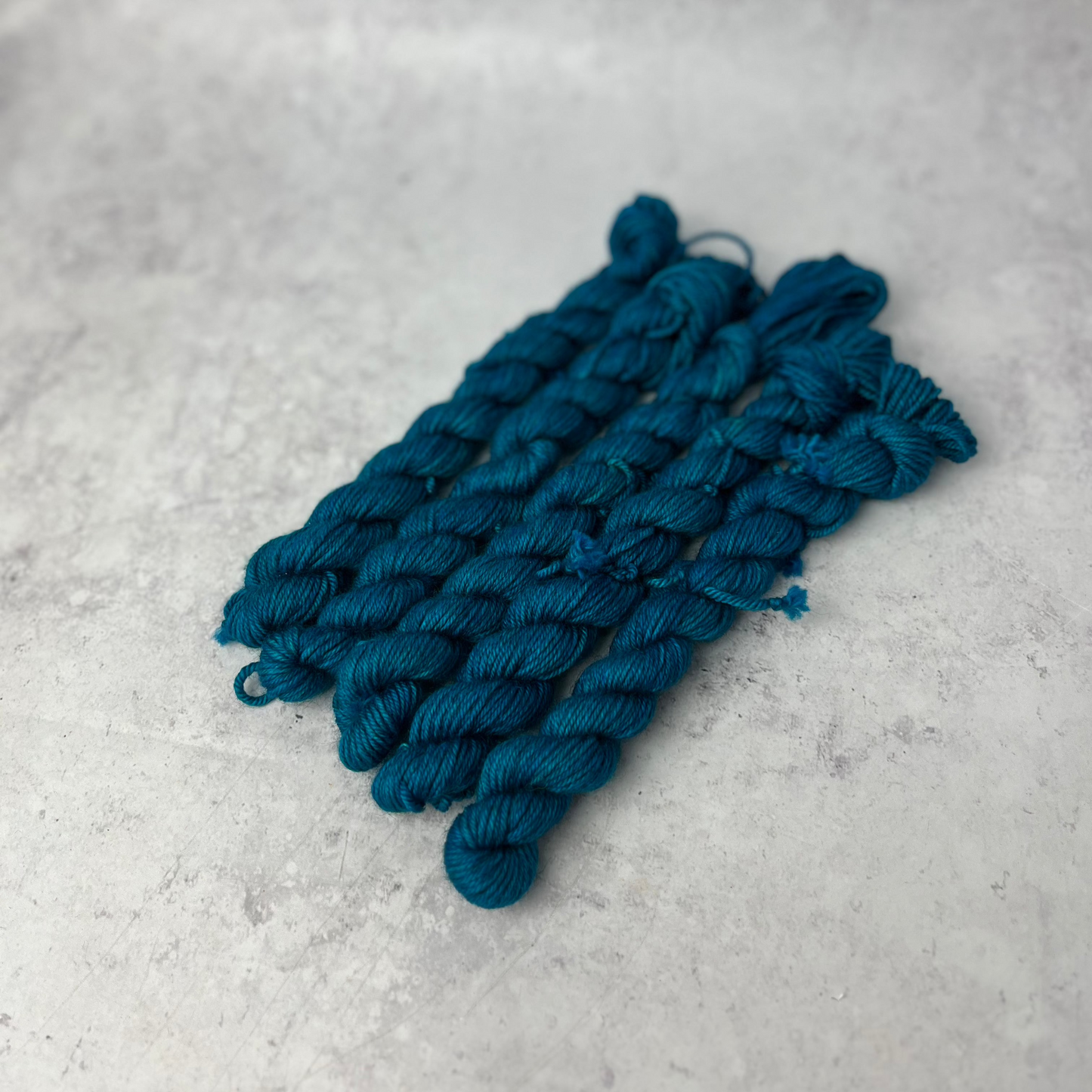 Turquoise Yak DK mini skein shown against a neutral background.