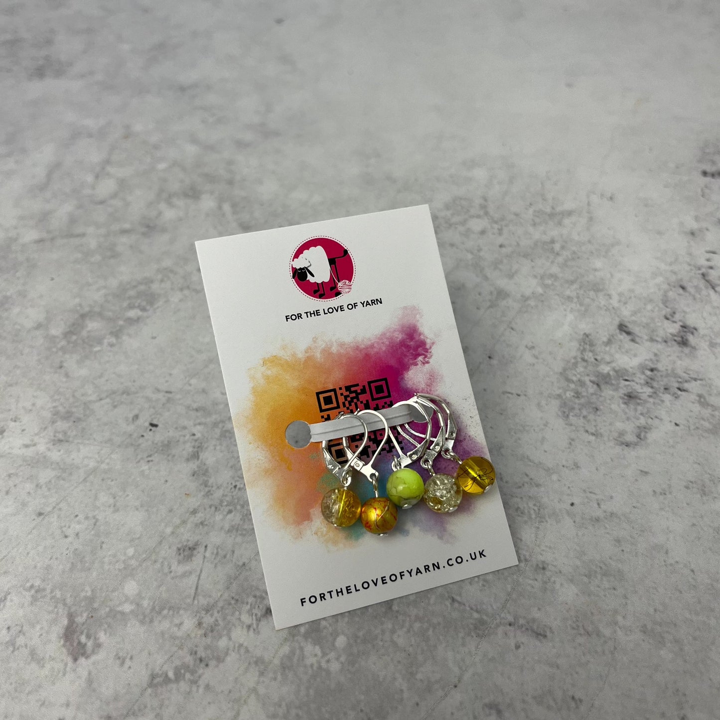 Set of yellow crochet style stitch markers on backing card.