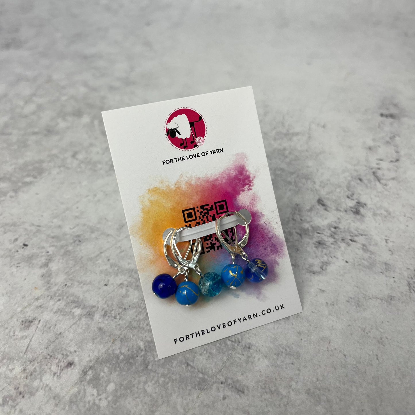 Set of blue crochet style stitch markers on backing card.