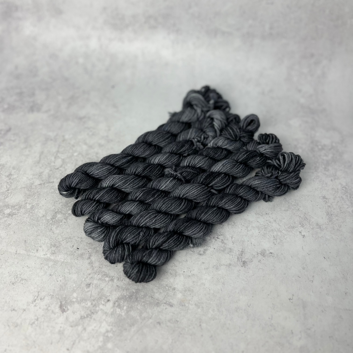 Charcoal Grey Merino Nylon Mini skein shown against a neutral background.