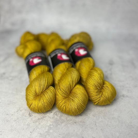 Warm, golden yellow yarn shown on a neutral background.