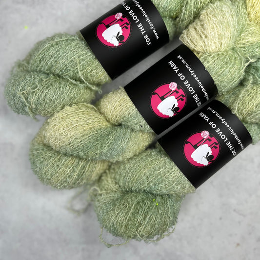 Subtle green baby alpaca silk skein against a neutral background.