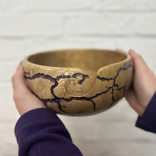 Purple XL yarn bowl being held against a neutral background to give an idea of the size of the bowl.