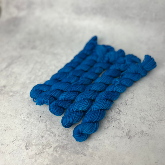 Turquoise Merino Nylon mini skein shown against a neutral background.
