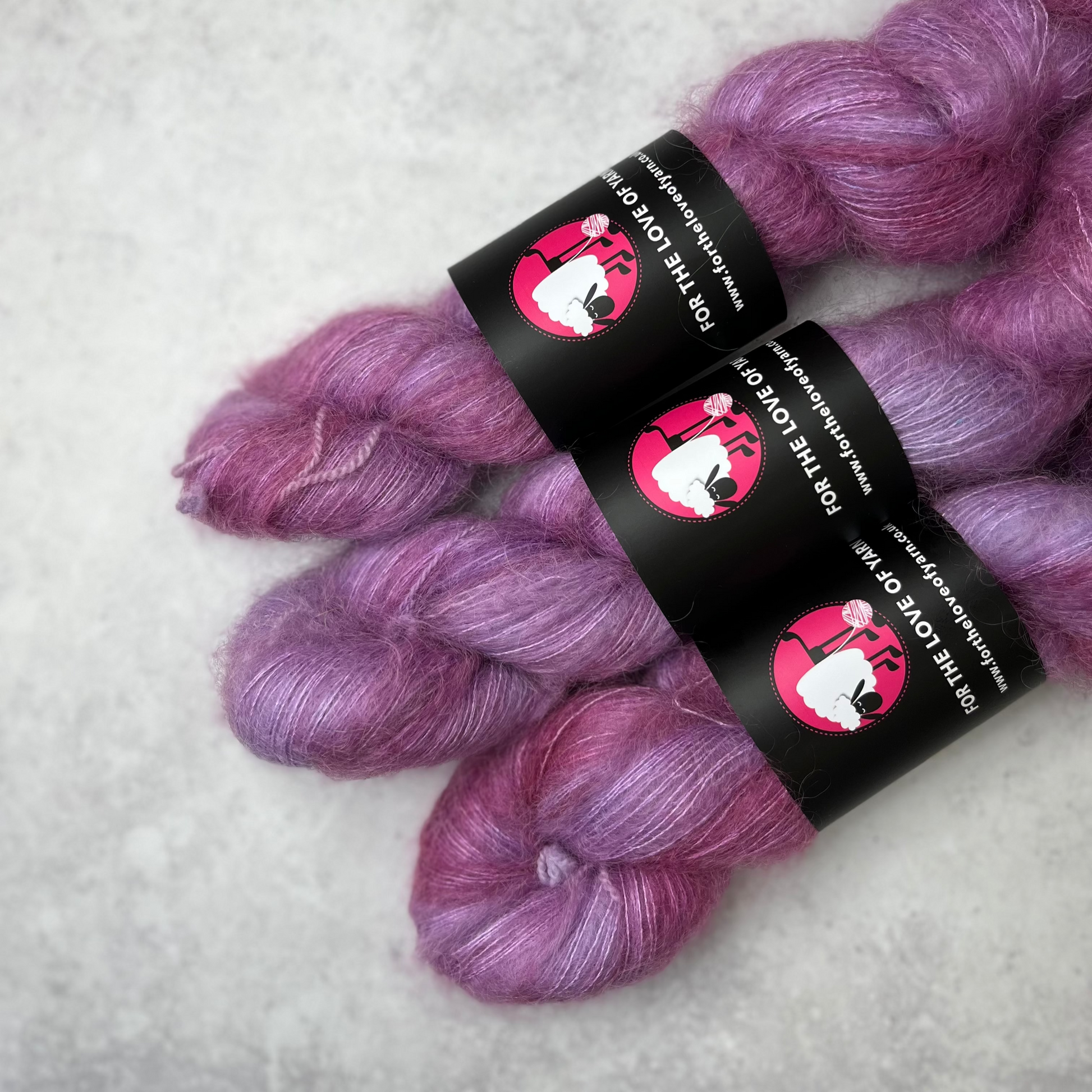 Three purple skeins against a grey background.